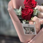 Сборный букет из красных роз, нежно-розовой кустовой розы и эвкалипта в розовой матовой упаковке.