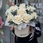 Букет в белой коробке из 15 белых роз с зеленью.
